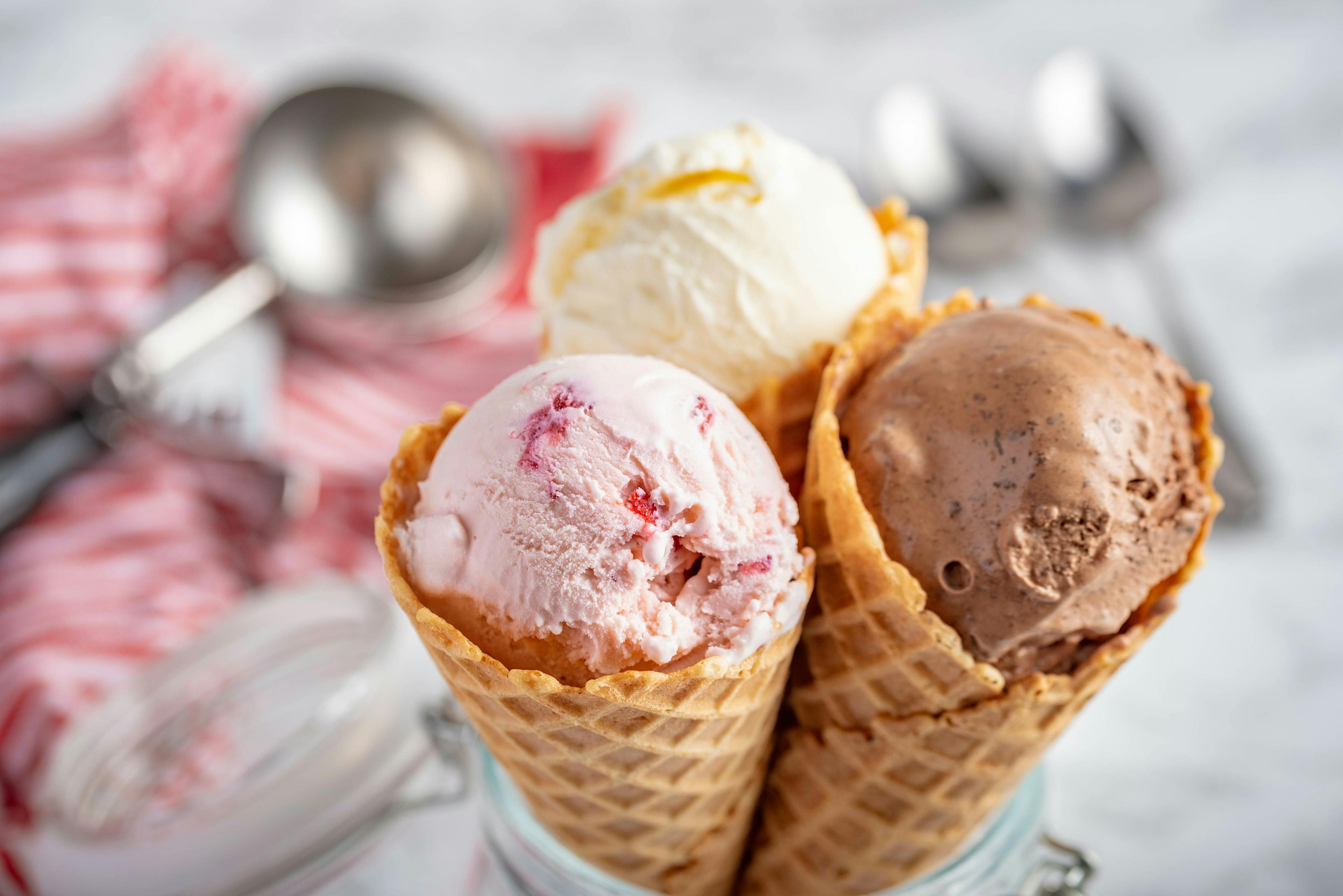 strawberry, vanilla, chocolate ice cream woth waffle cone on marble stone backgrounds | Image Credit: © ahirao - stock.adobe.com