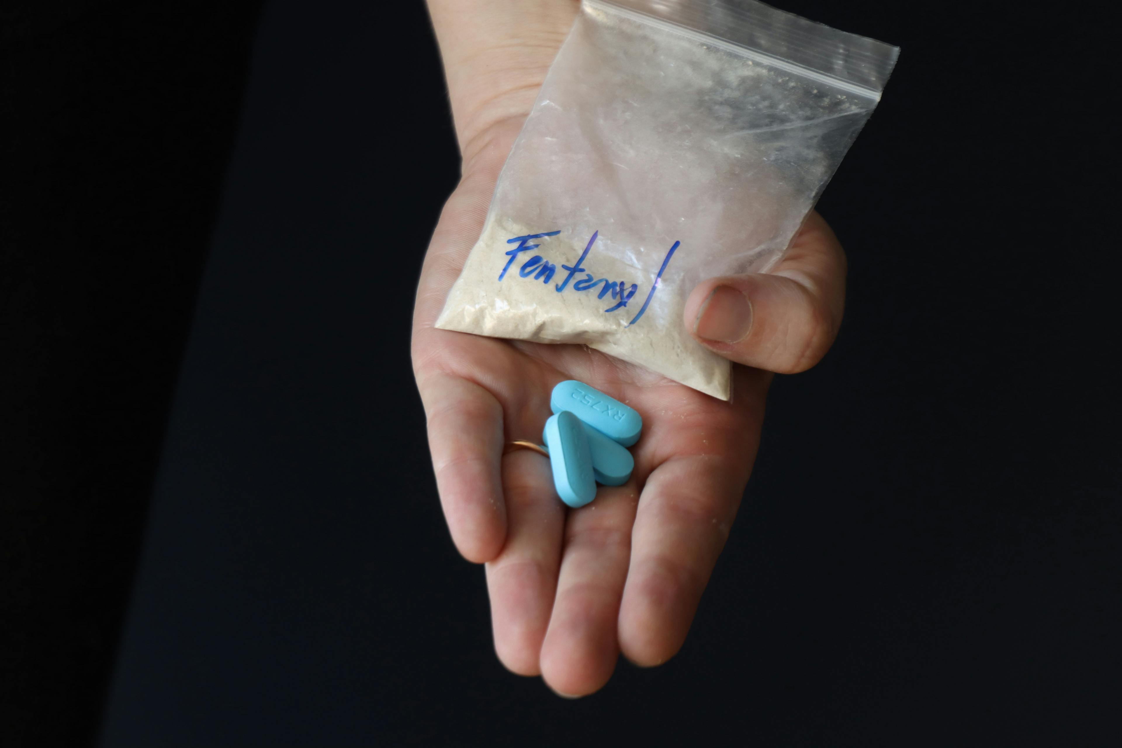 Woman holding a pack with fentanyl powder and pills to illustrate the drug addiction | Image Credit: © Jeniffer - stock.adobe.com