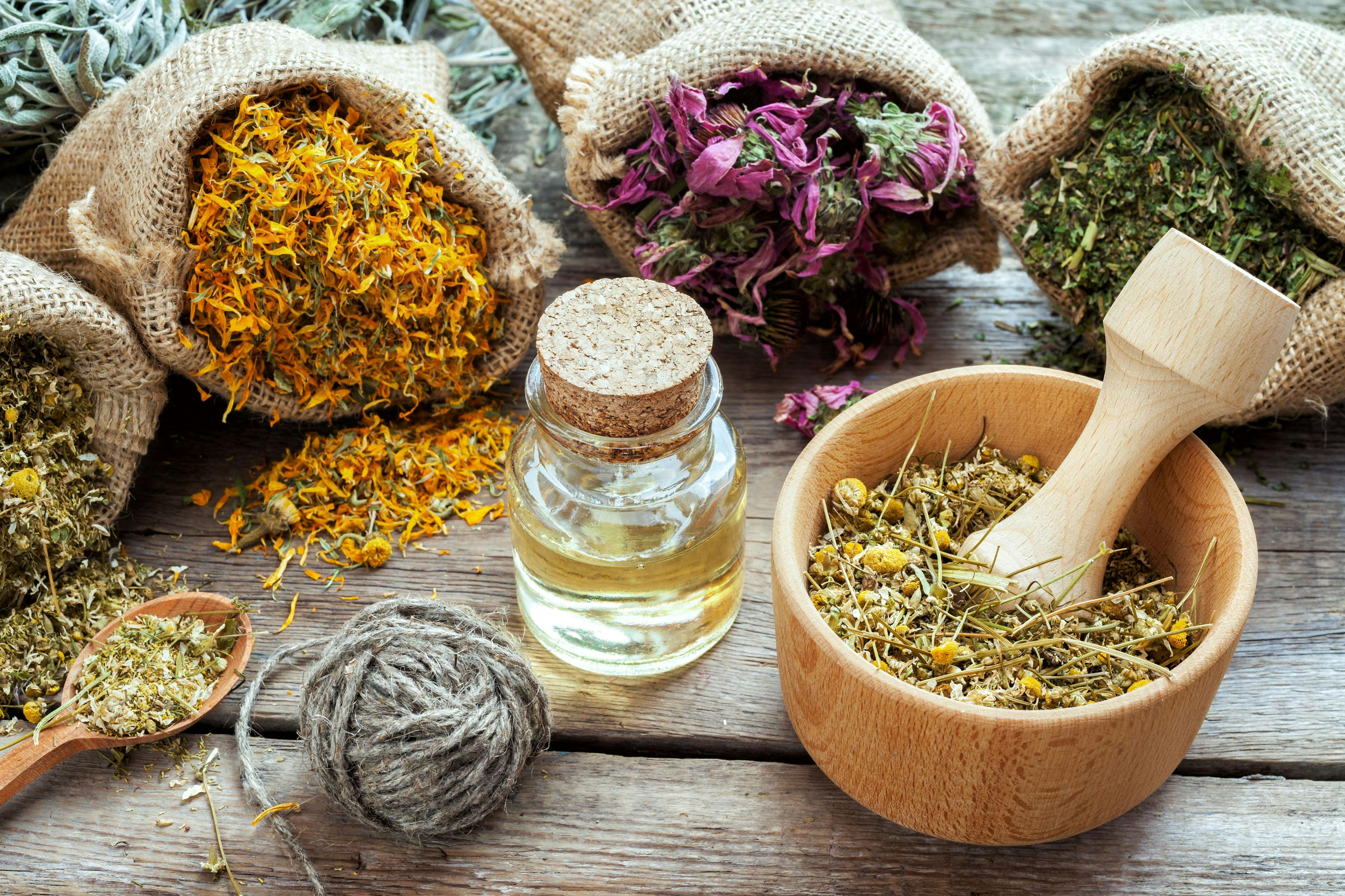 Healing herbs in hessian bags, mortar with chamomile and essenti | Image Credit: © chamillew - stock.adobe.com
