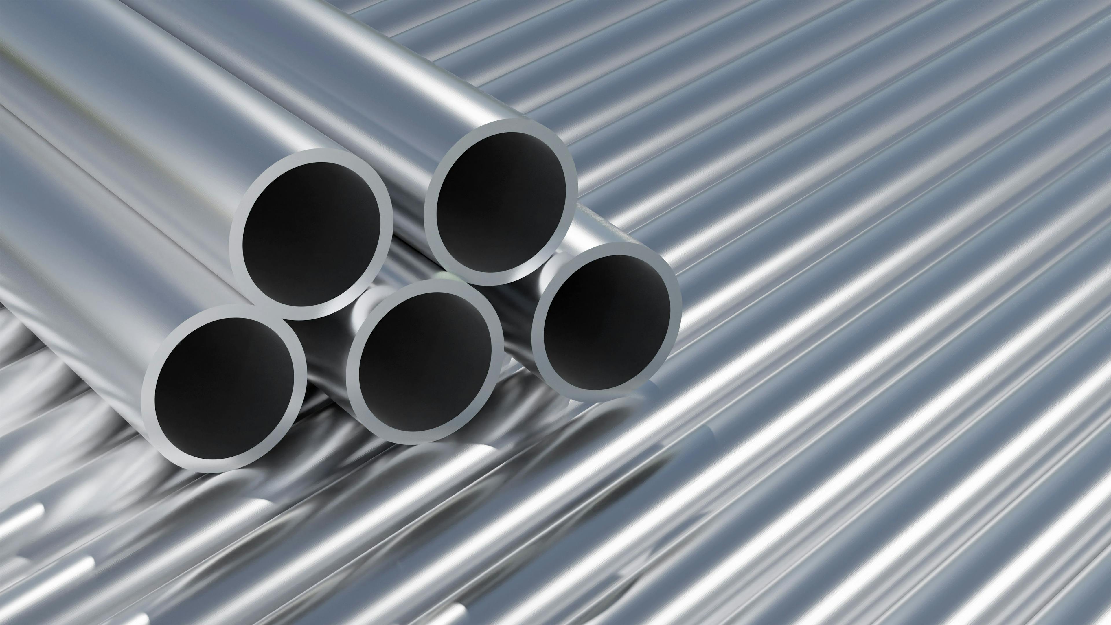 Group, set of simple new high quality shiny galvanized stainless steel metal aluminium alloy pipes stacked, iron pipes, industrial construction materials, supplies storage, warehouse stock, nobody | Image Credit: © Tomasz - stock.adobe.com