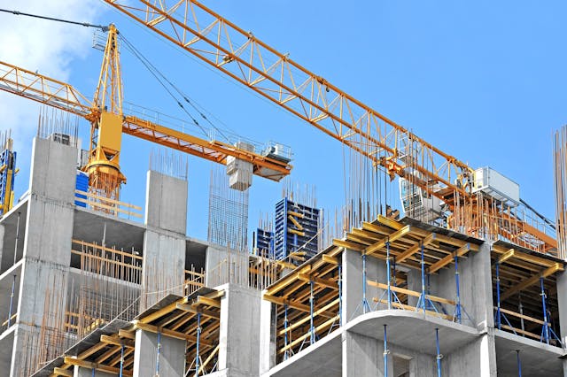 Crane and building construction site against blue sky | Image Credit: © Unkas Photo - stock.adobe.com.