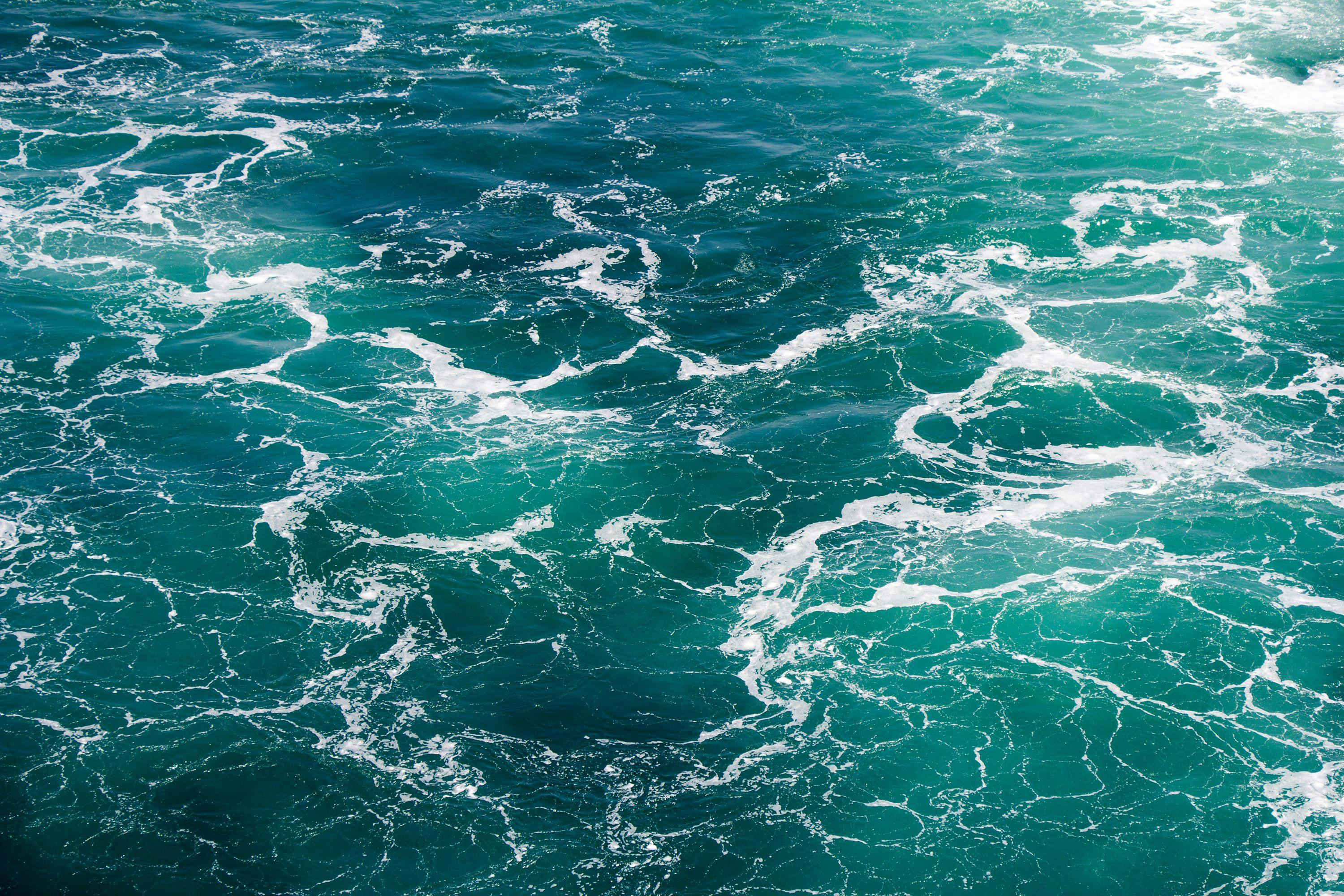 Turquoise green Seawater with sea foam as background | Image Credit: © smuki - stock.adobe.com