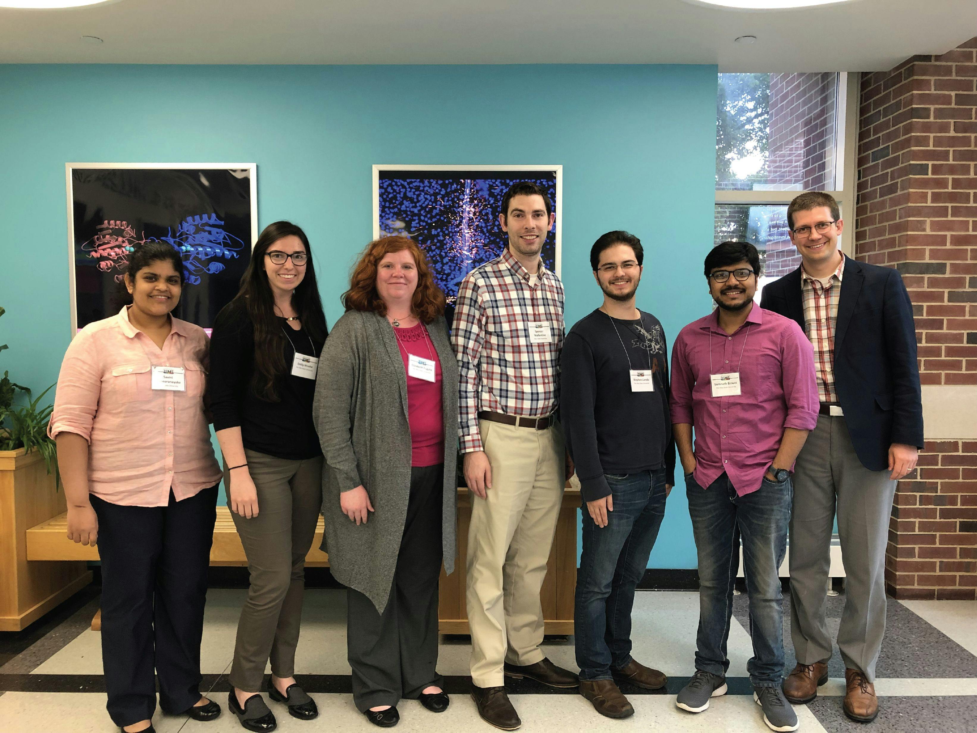 FIGURE 4: Members of the Baker research group present at the International Symposium on Molecular Spectroscopy at University of Illinois, Urbana-Champaign in 2019. Left to right: Savini Bandaranayake, Emily Hruska, Elizabeth Fugate, Spencer Wallentine, Stephen Londo, Somnath Biswas, and L. Robert Baker.