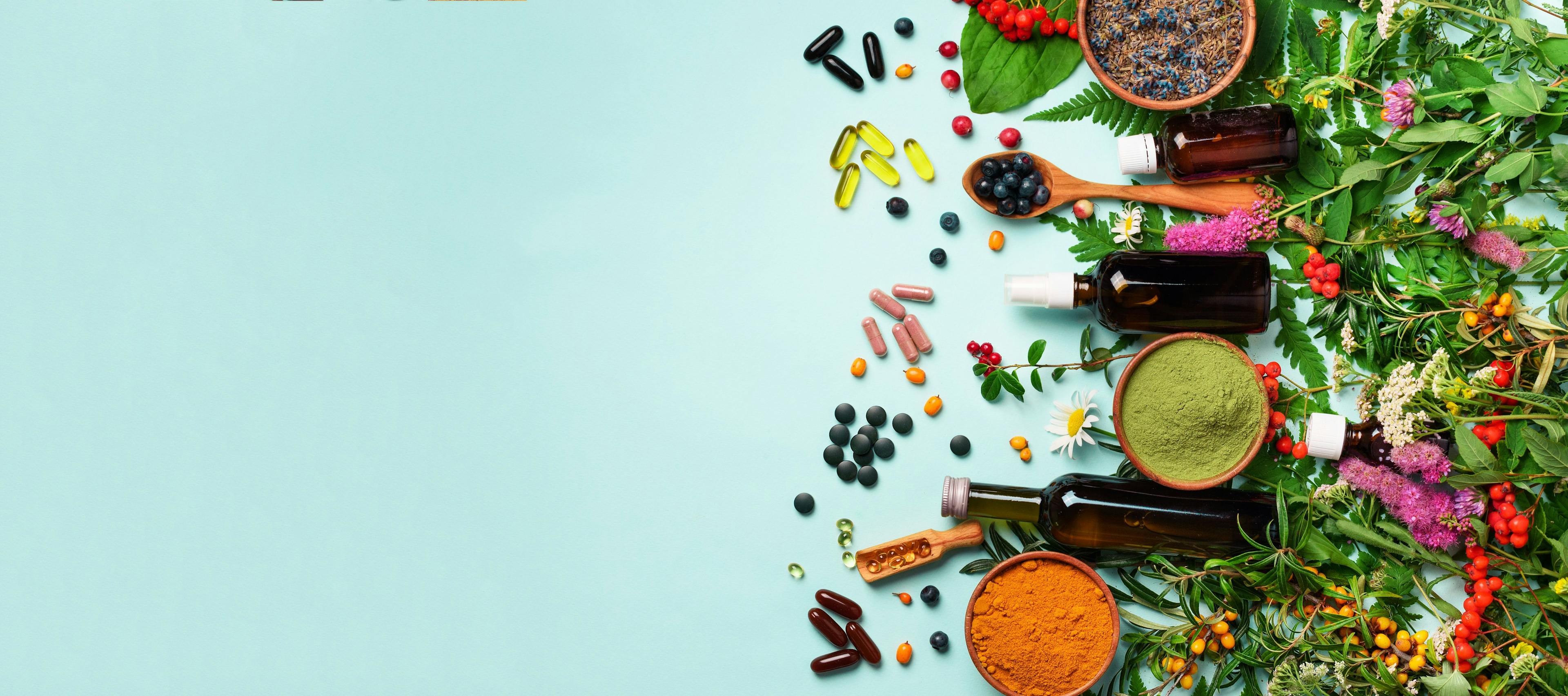 Holistic medicine approach. Healthy food eating, dietary supplements, healing herbs and flowers. Turmeric, dried lavender, spirulina powder in wooden bowls, fresh berries, omega acid capsules | Image Credit: © jchizhe - stock.adobe.com