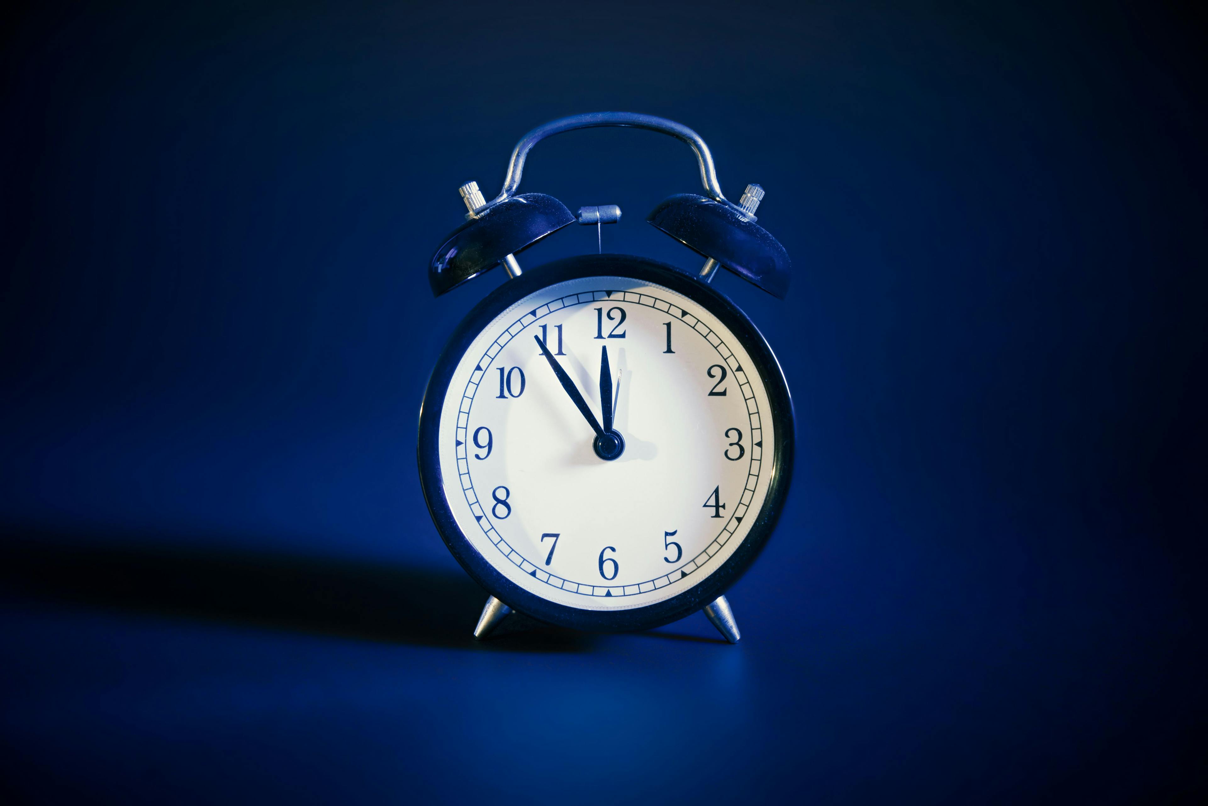 Analog clock on blue background | Image Credit: © Proxima Studio - stock.adobe.com